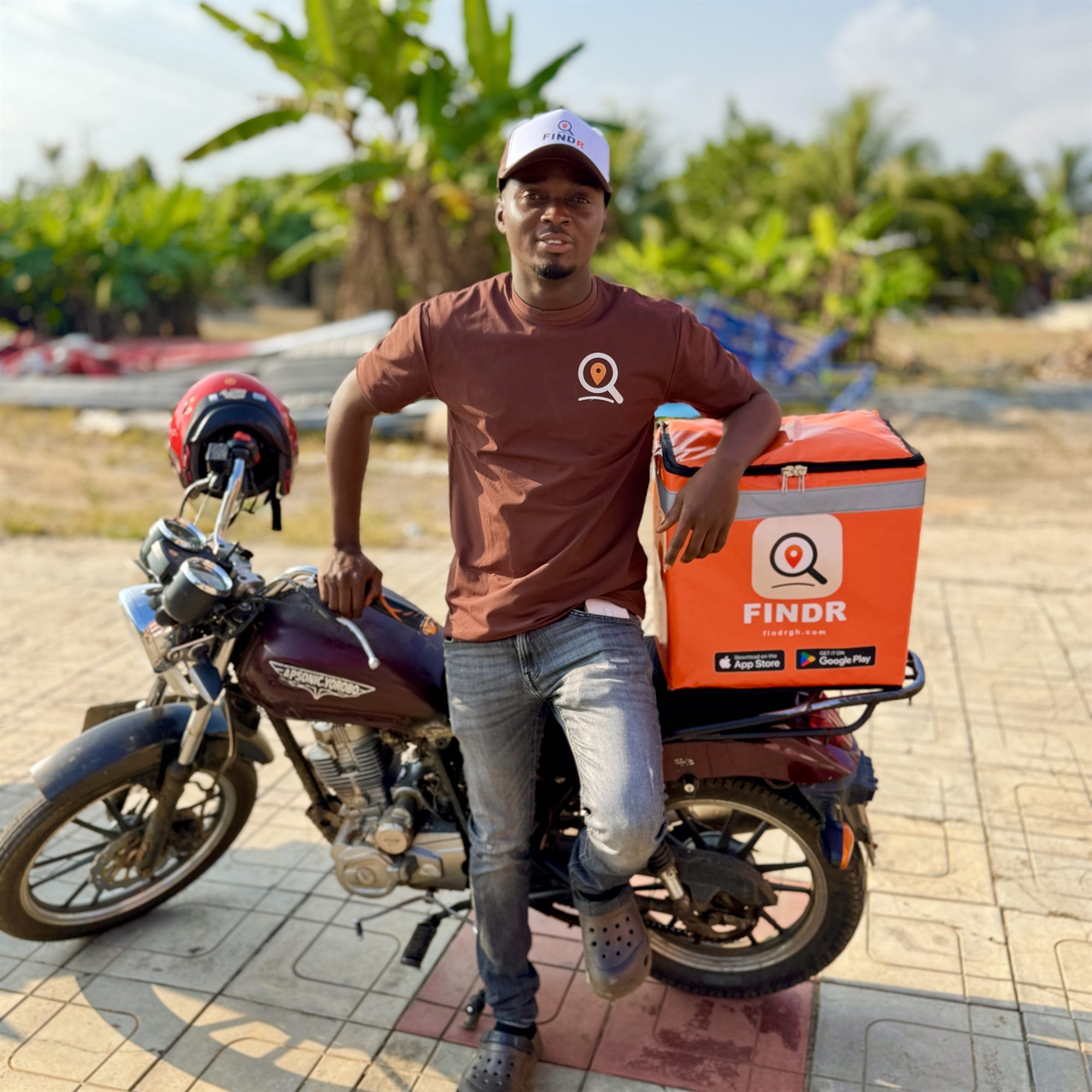 A FINDR rider standing beside his motorbike